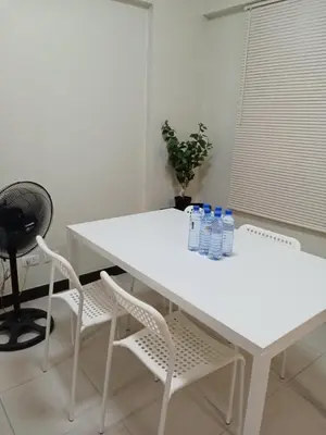 a white table with two chairs and bottles of water at Asteria Lovely Staycation in Manila