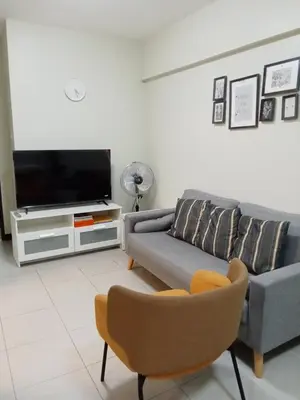 a living room with a couch and a tv at Asteria Lovely Staycation in Manila