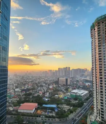 a view of a city at sunset from a building at BGC Uptown Parksuites King Bed with Balcony Sunset and City View in Manila