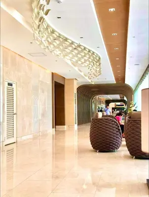 a lobby with chairs and a chandelier in a building at Cozy 642 shore3 residence tower2 near MOA in Manila