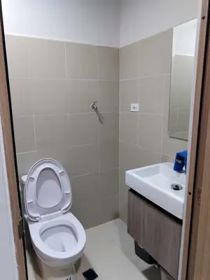 a bathroom with a toilet and a sink at Cozy 642 shore3 residence tower2 near MOA in Manila