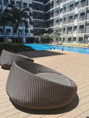 two wicker benches sitting in front of a large building at Moa shore 3 residence in Manila