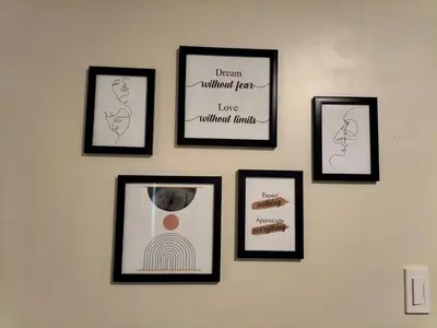 a wall with four framed pictures on a wall at STANFORD SUITES 3 in Silang