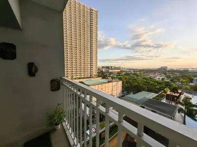 a balcony with a view of a building at Comfy unit at SMDC Breeze Residences near PICC, MOA, NAIA Airport, CCP with a view! in Manila