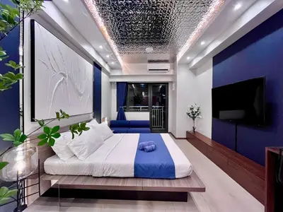 a bedroom with a large bed with a blue wall at Deluxe Executive Corner Unit in Makati in Manila
