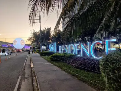 a sign for a hotel on a street with palm trees at Shell Residences Condo Suite Staycation near MOA and Airport in Manila