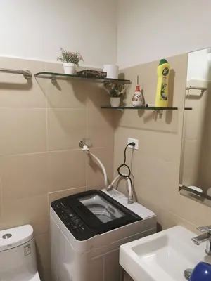 a small bathroom with a washing machine and a sink at Moa shore 3 staycation in Manila