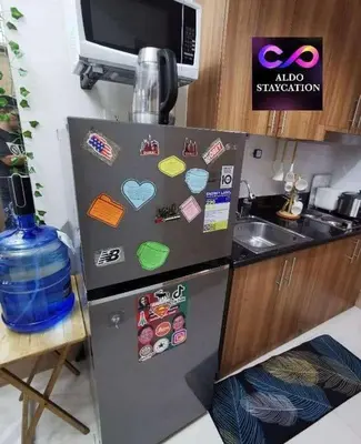 a refrigerator with magnets on it in a kitchen at Moa shore 3 staycation in Manila