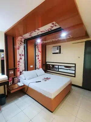 a bedroom with a large bed in a room at Hotel Sogo Alabang Southroad in Manila
