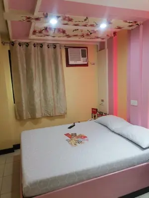 a bed in a room with a pink and purple wall at Hotel Sogo Alabang Southroad in Manila