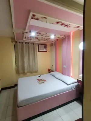 a bedroom with a bed in a pink room at Hotel Sogo Alabang Southroad in Manila