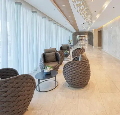 a lobby with chairs and tables in a building at Cozy 1-bedroom unit in Shore 3 Residences in Manila