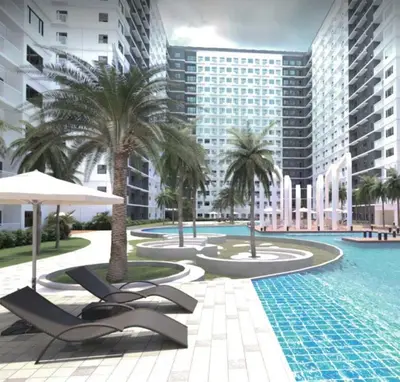 a swimming pool with chairs and palm trees and buildings at Cozy 1-bedroom unit in Shore 3 Residences in Manila