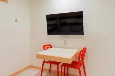 a table with two chairs and a tv on a wall at Hotel Sogo Guadalupe in Manila