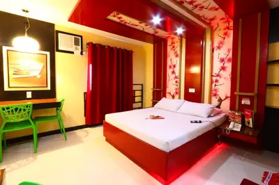 a bedroom with a bed and a desk in it at Hotel Sogo Makati Avenue in Manila