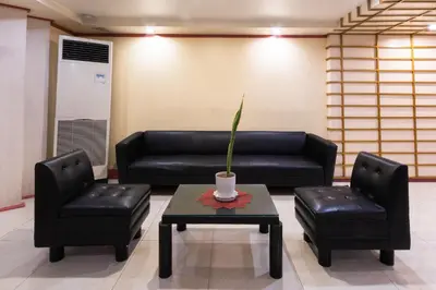 a living room with a couch and two chairs and a table at Hotel Sogo Kalentong in Manila
