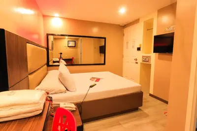 a small room with a bed and a mirror at Hotel Sogo Alabang Rotonda in Manila