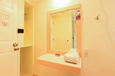 a bathroom with a mirror and a sink with towels at Hotel Sogo Alabang Rotonda in Manila