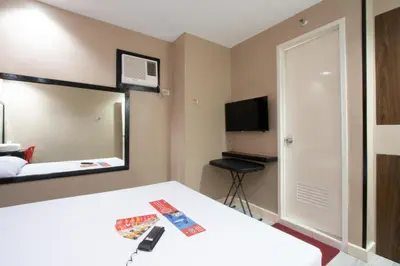 a hotel room with a bed and a mirror at Hotel Sogo Alabang Rotonda in Manila