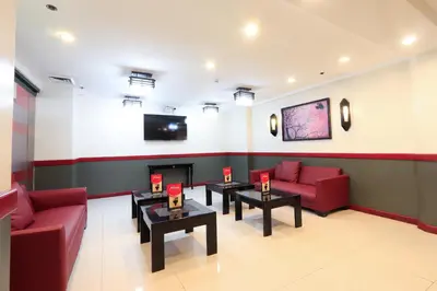 a waiting room with red couches and a fireplace at Hotel Sogo Alabang Rotonda in Manila