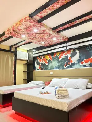a bedroom with two beds and a painting on the wall at Hotel Sogo Molino in Cavite