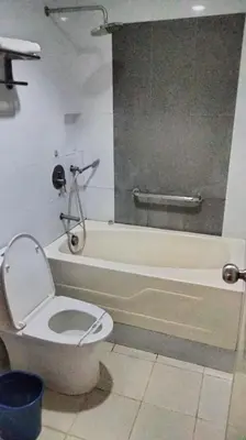 a bathroom with a toilet and a bath tub at Hotel Sogo Molino in Cavite