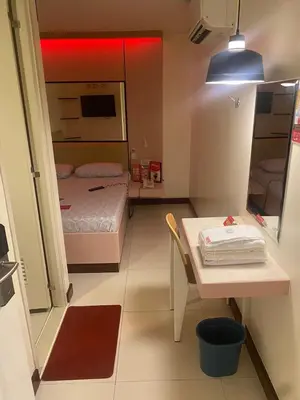 a small room with a bed and a table in it at Hotel Sogo San Pedro in San Pedro