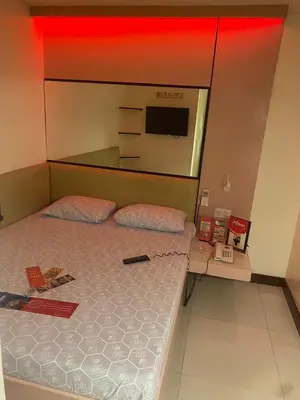 a bedroom with a bed and a tv on the wall at Hotel Sogo San Pedro in San Pedro