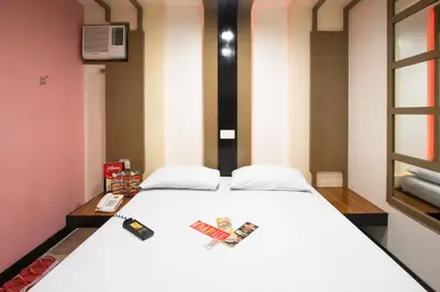 a bedroom with a white bed with two remote controls at Hotel Sogo Santolan in Manila