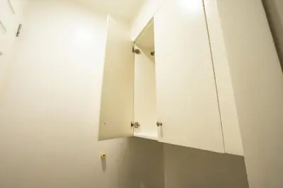 a kitchen with white cabinets and a mirror at Hotel Sogo Santolan in Manila