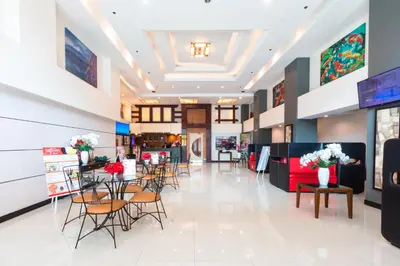 a lobby of a store with chairs and tables and flowers at Hotel Sogo Santolan in Manila