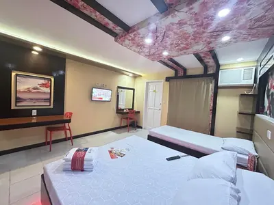a bedroom with two beds and a desk in it at Hotel Sogo Sta Rosa in Santa Rosa