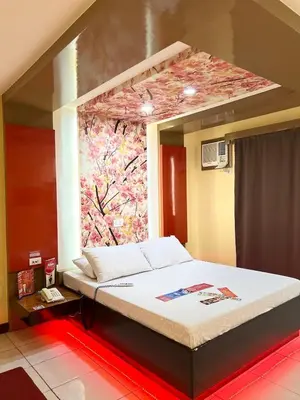 a bed in a room with a painting on the wall at Hotel Sogo Sta Rosa in Santa Rosa