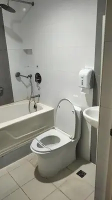 a white bathroom with a toilet and a sink at Hotel Sogo Sta Rosa in Santa Rosa