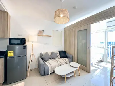 a living room with a couch and a refrigerator at GemstoneBR in SMDC Shore Residences in Manila