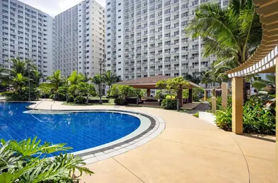 a swimming pool in front of a large building at GemstoneBR in SMDC Shore Residences in Manila