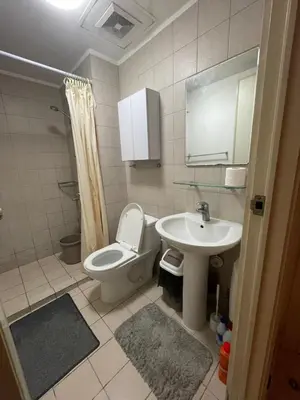 a bathroom with a toilet and a sink at SOHO Central EDSA Shaw Condo Pool front with SMART TV in Manila