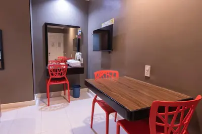 a dining room with red chairs and a wooden table at Hotel Sogo Santa Mesa in Manila