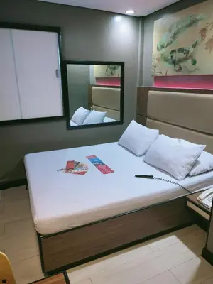a large bed in a room with a mirror at Hotel Sogo Edsa Taft in Manila