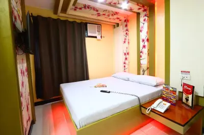 a bedroom with a bed and a telephone and a table at Hotel Sogo Yabut in Manila