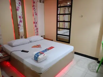 a bedroom with a white bed with a mirror at Hotel Sogo Yabut in Manila