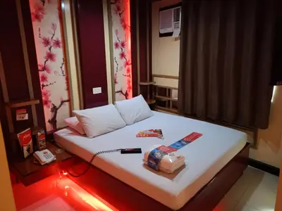 a small room with a white bed with lights on it at Hotel Sogo Yabut in Manila