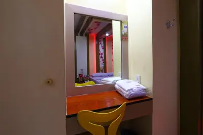 a vanity with a yellow chair in front of a mirror at Hotel Sogo Yabut in Manila