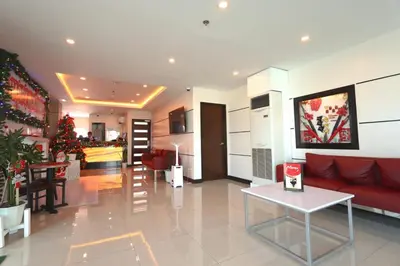 a living room with a red couch and a kitchen at Hotel Sogo General Trias in General Trias