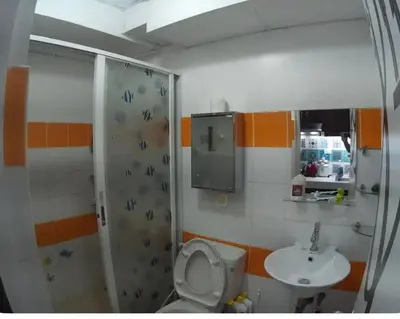 a bathroom with a shower and a toilet and a sink at Rsquared Condo in Manila