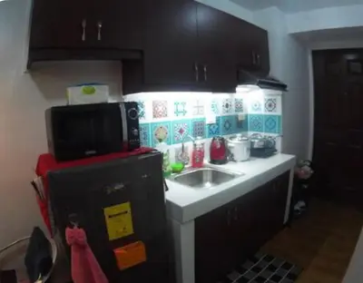 a small kitchen with a sink and a microwave at Rsquared Condo in Manila