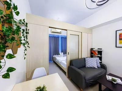 a living room with a chair and a bed in a room at 1BR Condotel with Balcony at SM Light Residences #LT06 in Manila