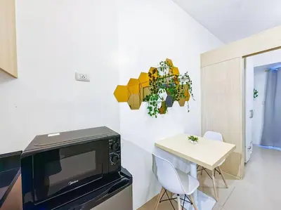 a living room with a tv and a table with chairs at 1BR Condotel with Balcony at SM Light Residences #LT06 in Manila