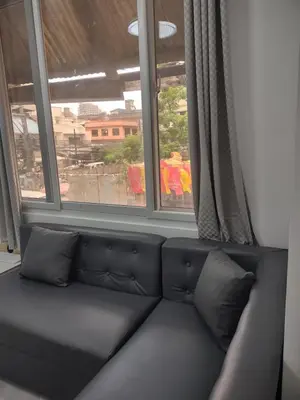 a black couch in a room with a window at Bellas Apartment u2 in Manila
