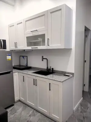 a kitchen with white cabinets and a sink at Bellas Apartment u1 in Manila